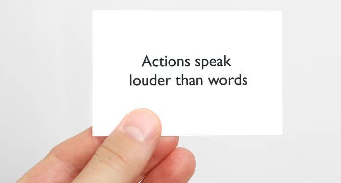 A white card printed with the words 'Actions speak louder than words'