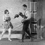 Petite-woman-in-dress-boxing-with-gigantic-man