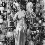 Woman-in-party-dress-surrounded-by-balloons-and-streamers